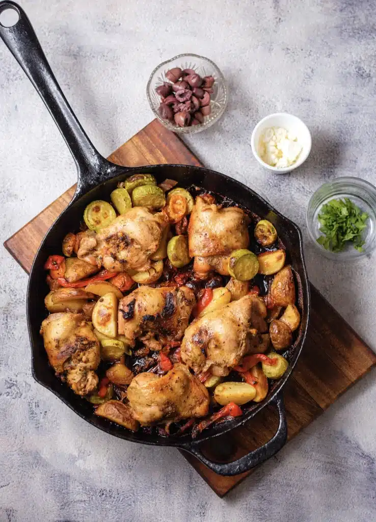 Greek sheet pan chicken, the skillet version, seen from above before the feta and olives go on