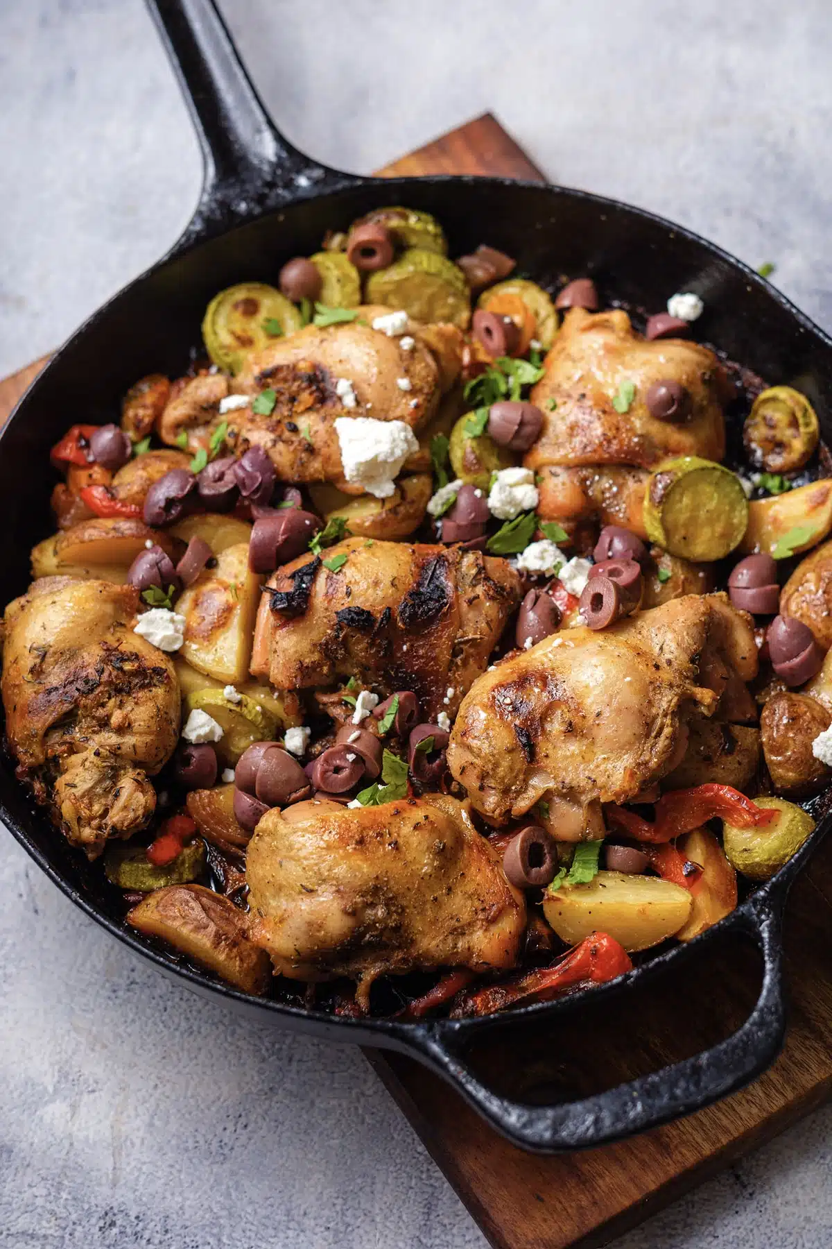 The skillet version with feta, olives and parsley scattered over roasted thighs, potatoes and zucchini