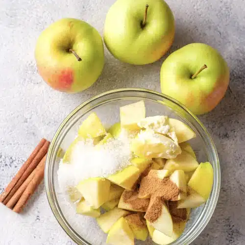 The fruit chunks tossed with butter, sugar and spice in the glass bowl, ready for the microwave