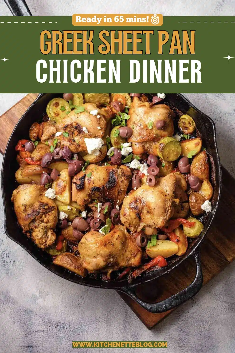 Roasted chicken thighs with potatoes, zucchini, peppers, olives and feta in a cast-iron skillet, seen from above
