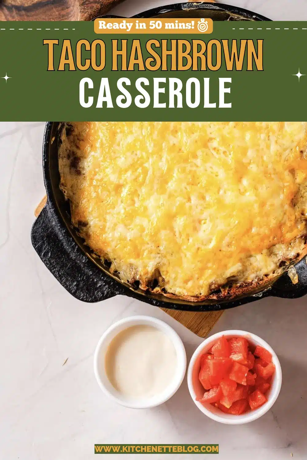 A cast-iron skillet of shredded spuds and seasoned beef under melted cheese, with bowls of sour cream and diced tomato